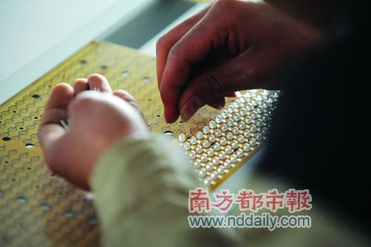 工人忙著安裝用于燈具發(fā)光的LED燈珠，這類工作處于LED燈具生產(chǎn)的最下游。資料圖